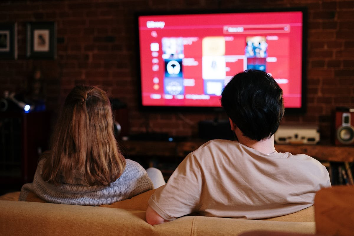 Person using a TV remote while watching television at home