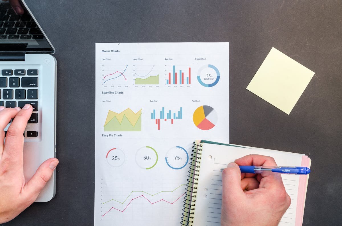 Person reviewing data charts and notes on a desk