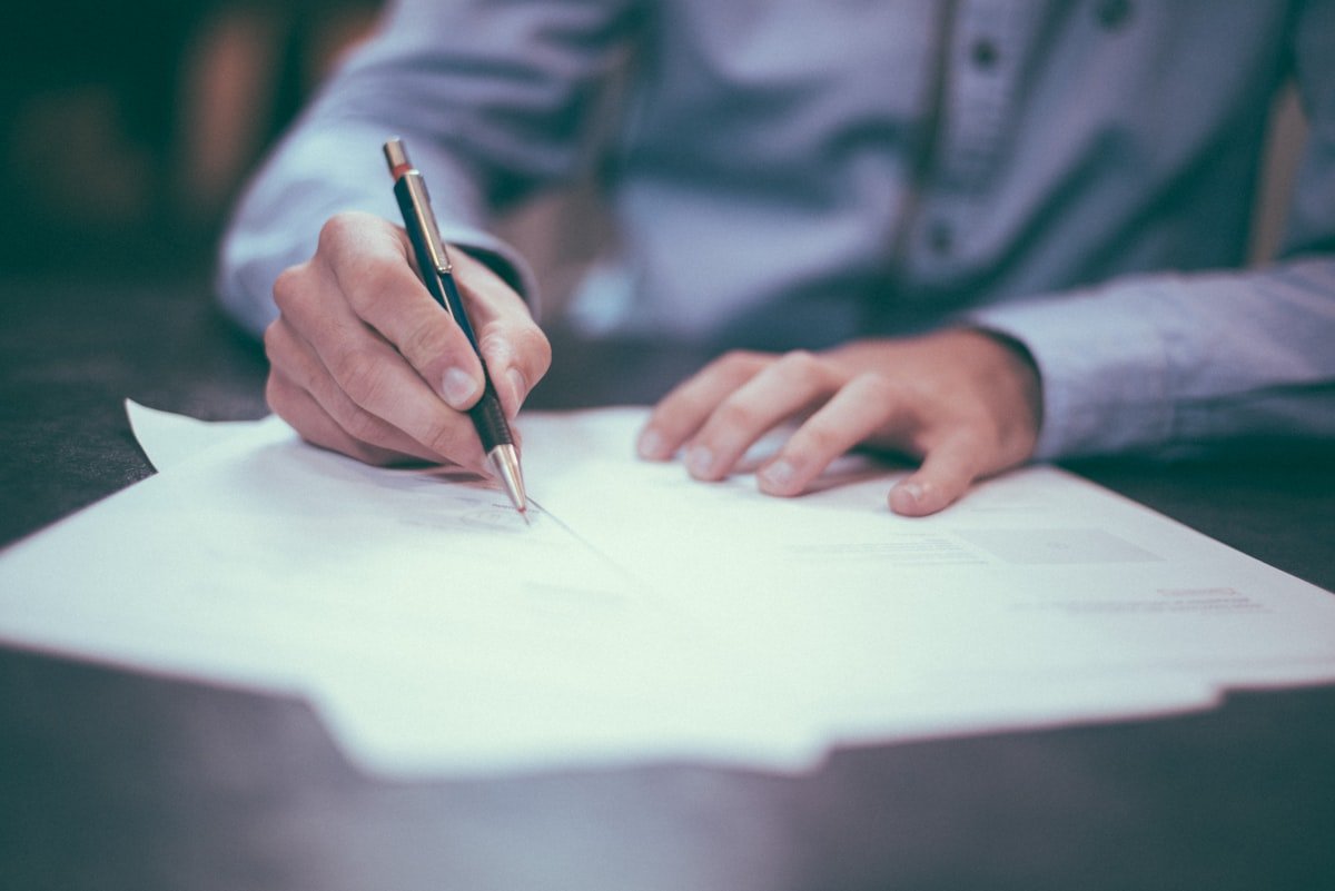 Invoice papers and financial documents on a desk while checking a fake PayPal bill