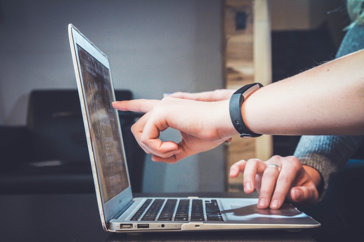 Person using a laptop and phone while checking online messages