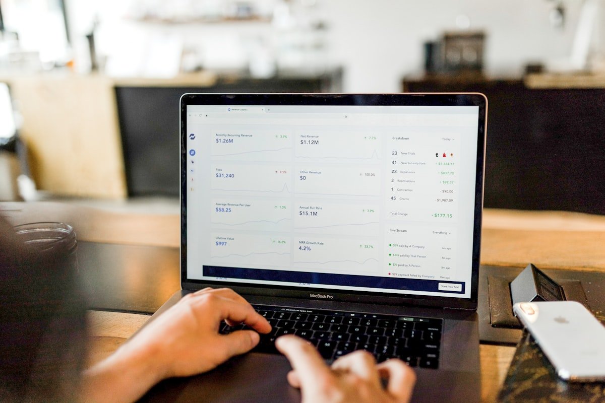 Person working on a laptop while checking online marketplace messages
